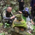 ผู้ลงพื้นที่สังเกตชิ้นส่วนหินที่มีมอสปกคลุม ภาพจากชุดที่ต้นทางนำมาเผยแพร่ประกอบเรื่องปราสาทดินแดง